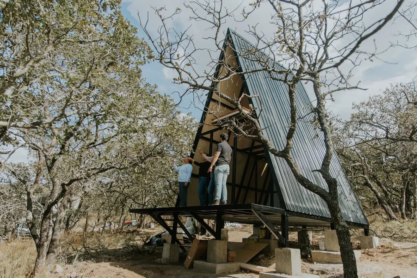 People working together on a compact A-frame home in the woods